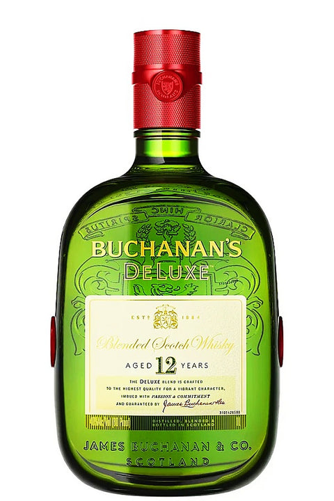 A bottle of Buchanan's Deluxe 12-year-old blended Scotch whisky in a distinctive green glass bottle with a red screw cap and a cream-colored front label.