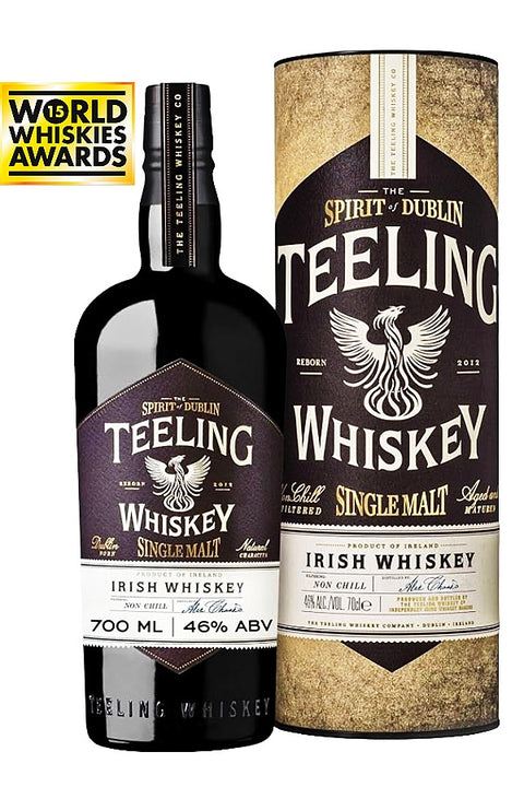 A bottle of Teeling Whiskey next to its cylindrical packaging box, featuring a black bottle with a dark brown and white label, and a matching box with a textured gold and brown design. A 'World Whiskies Awards' badge is visible in the top left corner.